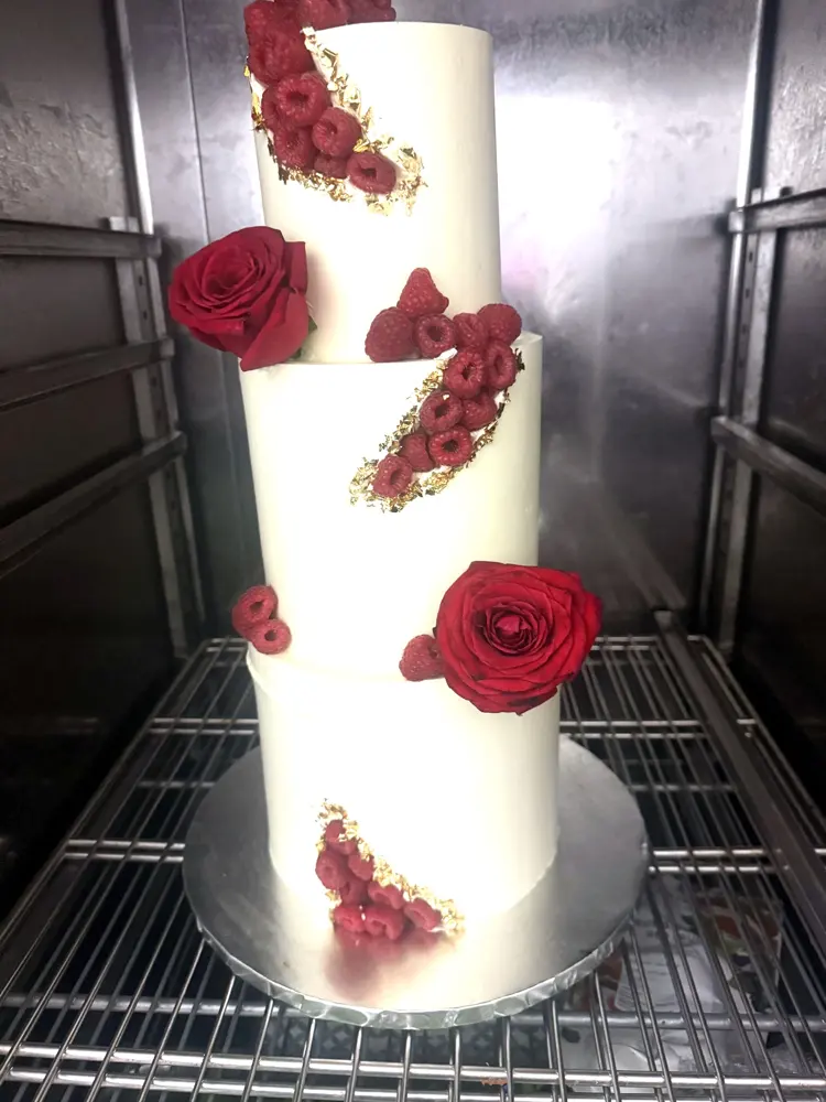 Pièce montée de mariage blanche décorée de roses rouges